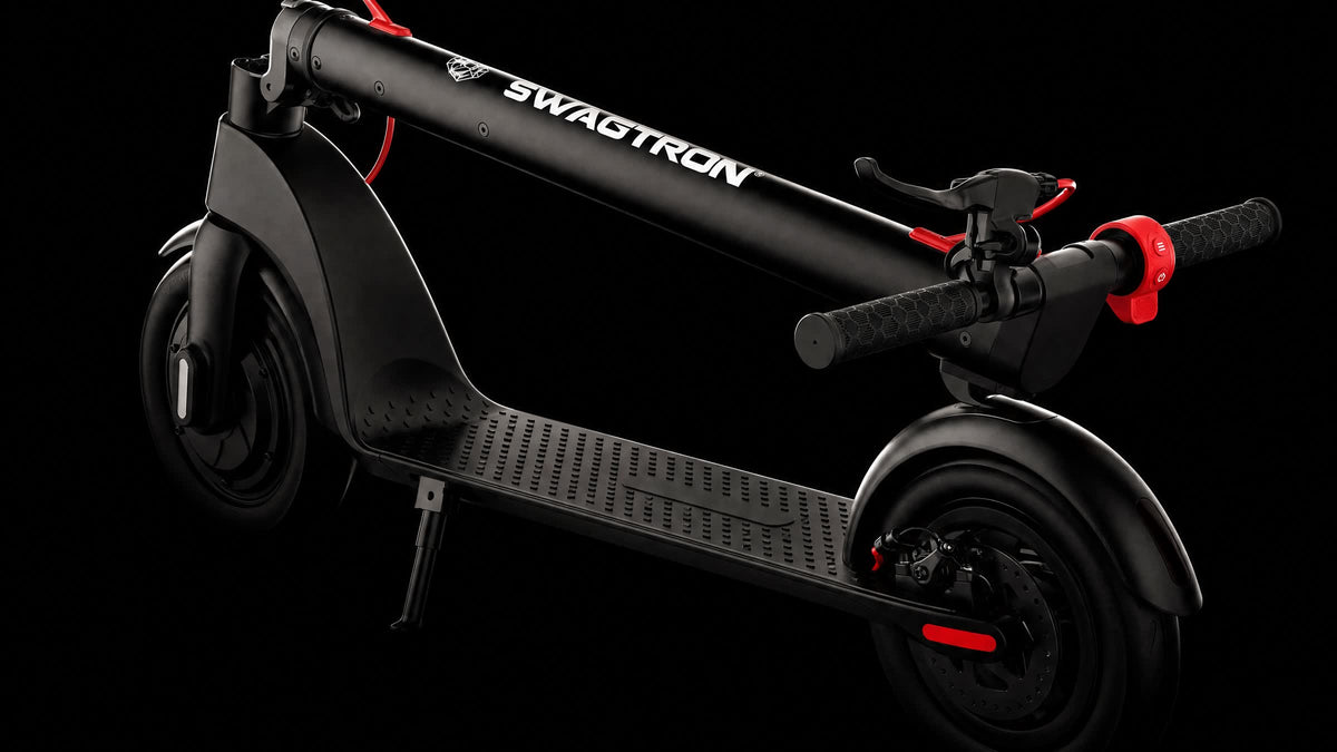 SWAGTRON GlideX electric scooter folded, stem lying over the deck, with red brake cables and grips, on black
