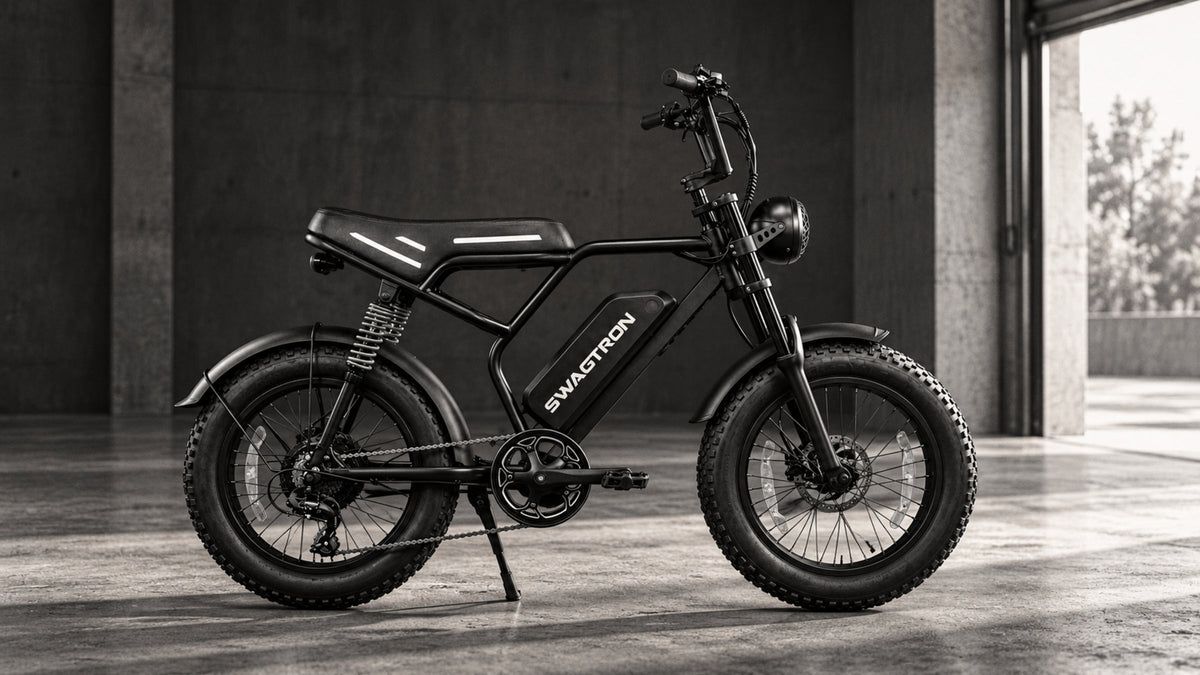 Black-and-white side view of a SWAGTRON UrbanCruise e-bike on its kickstand in a concrete warehouse